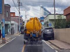 도로를 식히기 위해 살수차가 도로에 물을 뿌리며 운행중인 모습