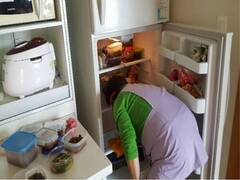 냉장고를 깨끗하게 청소중인 생활도우미 모습