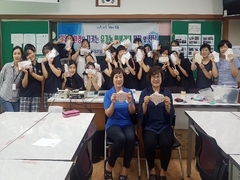 면생리대 사용 캠페인 행사에 참여중인 학생들과 강사과 손에 면생리대를 들고 기념 촬영을 하고 있는 모습