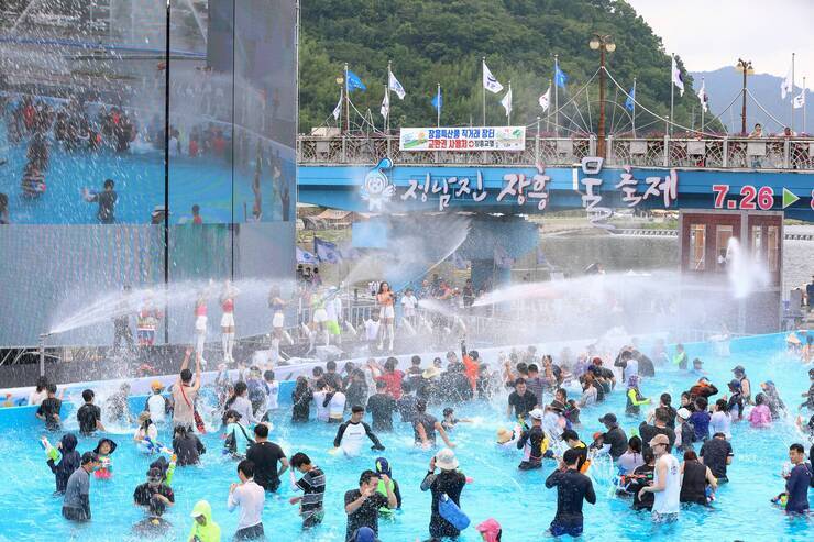 지상최대의 물싸움장 무대에서 물을 뿌리고 있고 관람객들이 물을 맞으며 즐거워 하고 있다.
