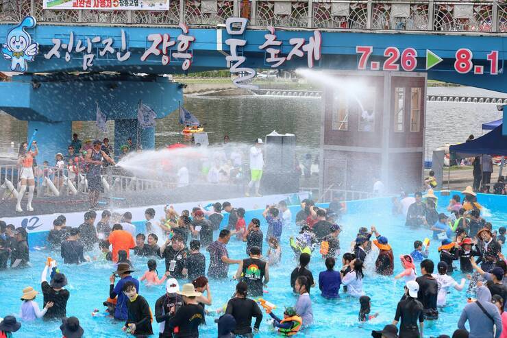 지상최대의 물싸움장 무대에서 물을 뿌리고 있고 관람객들이 물을 맞으며 즐거워 하고 있다.
