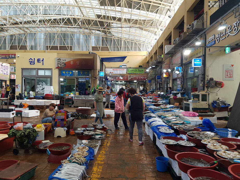 토요시장 어물전에서 상인들은 해산물을 진열해놓고 손님은 물품을 구경하고 있다