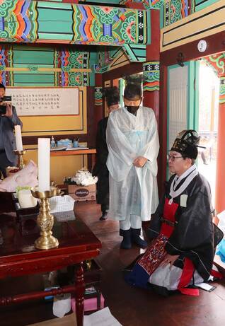 전통제례복을 입고 무릎을 꾾고 앉아있는 예를 드리고 있는 김성 군수와 죽산 안씨 문중 관계자들 사진(크게보기)
