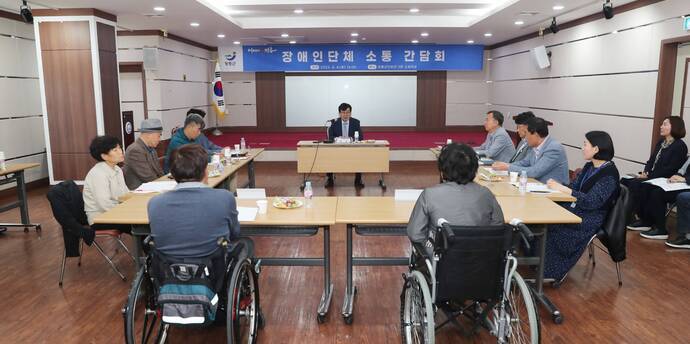 휠체어에 앉아있는 두명의 장애인 대표와 그외 8명의 장애인 단체 대표들과 군수 사진(크게보기)