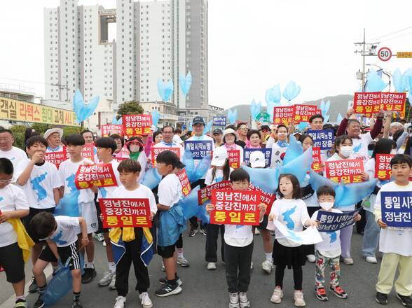 정남진에서 중강진까지 통일로 푯말을 들고 있는 아이들과 군민들 사진(크게보기)