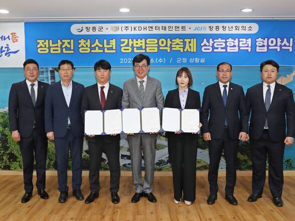 정남진 청소년 강변음악축제 상호협력 협약식, 협약서를 들고있는 군수와 KDH엔터테인먼트, 장흥청년회의소 관계자들 사진(크게보기)