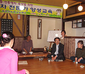 한 남성은 양성교육을 하며 다른 사람들은 경청하는 모습