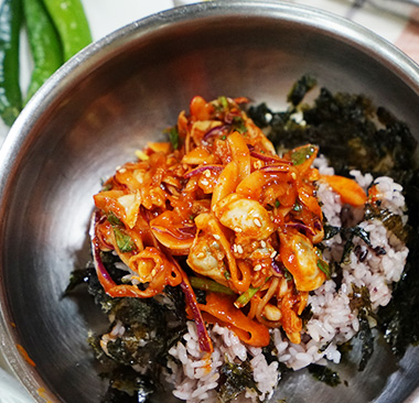 김가루와 밥이 담긴 그릇에 담긴 바지락 회무침