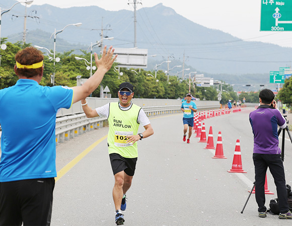 마라톤대회 참가자가 하이파이브를 하며 달려오는모습