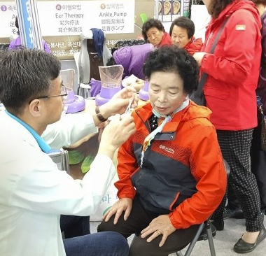 할머니 한분이 의사에게 건강을 체크하고 있는 모습