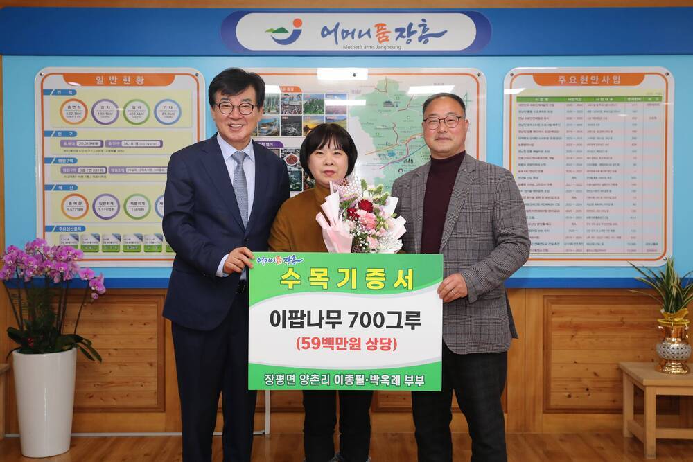 이팝나무 700그루(59백만원 상당) 수목기증서를 들고있는 군수와 장평면 양촌리 이종필·박옥례 부부 사진