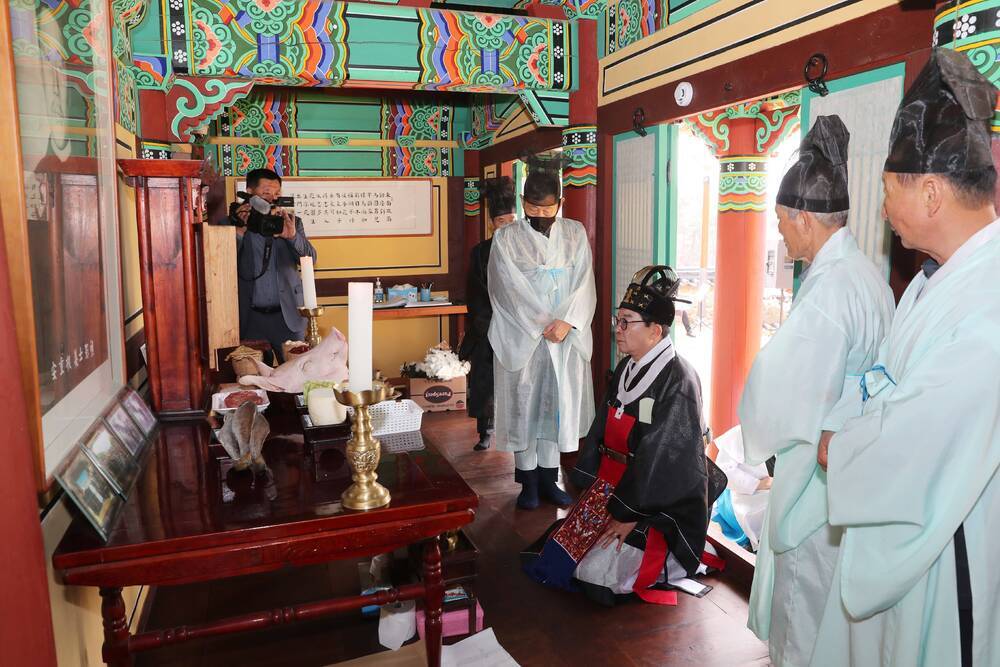 전통제례복을 입고 무릎을 꾾고 앉아있는 예를 드리고 있는 김성 군수와 죽산 안씨 문중 관계자들 사진