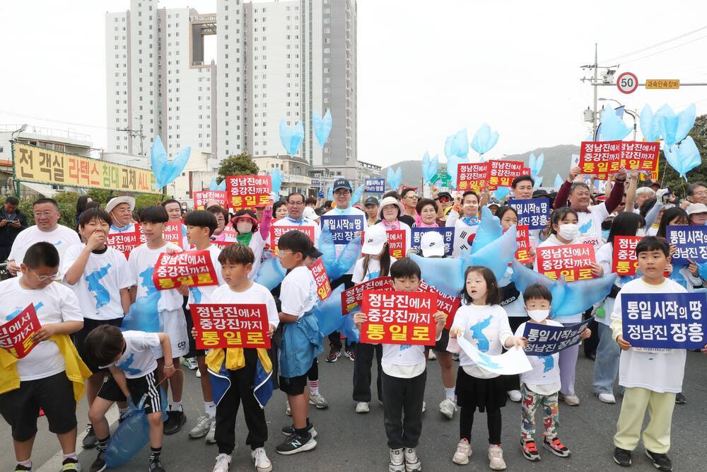 정남진에서 중강진까지 통일로 푯말을 들고 있는 아이들과 군민들 사진