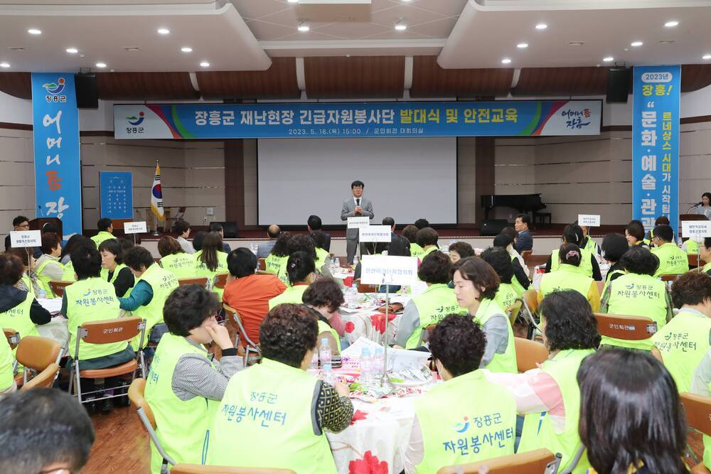 장흥군 재난현장 긴급자원봉사단 발대식 및 안전교육 2023.5.18(목) 15:00/군민회관 대회의실, 마이크를 들고 있는 김성 군수와 원탁에 앉아있는 자원봉사 요원들 사진